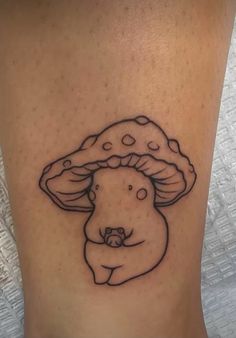 a woman's leg with a tattoo on it that has a mushroom on it