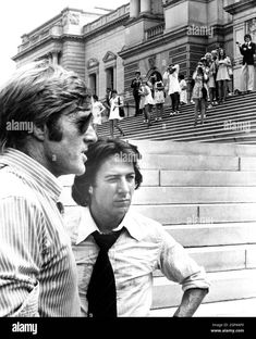 two men standing in front of some stairs with people taking pictures behind them - stock image