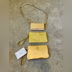 three purses laying on the floor next to each other, one yellow and one white