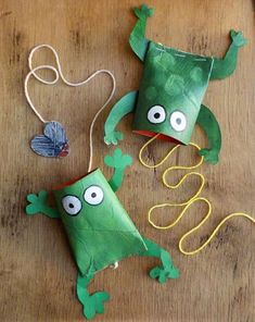 two green paper bags with googly eyes and one has a string attached to it