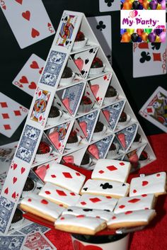 a table topped with lots of cards and cookies next to a cup filled with candy