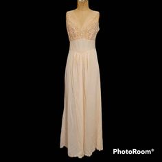 Shade between blush and ballet pink and in old stock condition is this pretty sleeveless gown with a lacy V neck bodice trimmed with small pearly buttons. Labeled a size 32, it measures just to 17 inches across the front of the bust while flat. From shoulder to hem, length is 55 inches. Please don't hesitate to convo if any Qs! Pet and smoke free environment. Sleeveless Lace Party Nightgown, Sleeveless Lace Nightgown For Party, Sleeveless Cream Nightgown For Wedding, Feminine Sleeveless Evening Nightgown, Sleeveless Lace Bodice Nightgown For Summer, Sleeveless Lace Nightgown For Evening, Sleeveless Nightgown With Lace Bodice For Wedding Night, Sleeveless Nightgown With Lace Bodice, Sleeveless Nightgown For Wedding In Spring