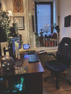 a computer desk with a laptop on top of it next to a chair and window