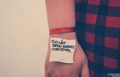 a woman's wrist with a note attached to it that says, don't open before christmas