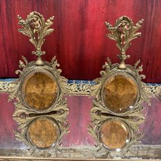 two ornately decorated gold candlesticks on a red velvet covered tablecloth,