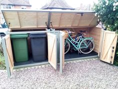 a bike is parked in the back of a shed with its doors open and trash cans