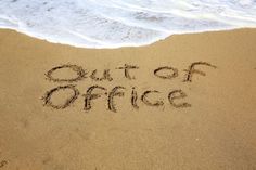 the word out of office written in sand at the beach with waves coming in to shore