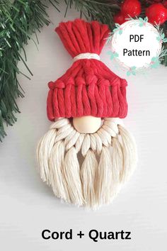 a red and white knitted gnome ornament hanging on a christmas tree branch