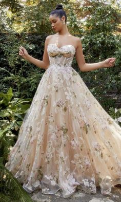 Here's a gorgeous strapless long champagne prom ball gown that is fun, flirty, and fabulous. With beautiful floral designs from the sweetheart neckline to the hem, this strapless long formal dress is a feminine choice for prom, military balls, and other black-tie events. A sheer corset bodice wraps around to the back of this long sweetheart evening gown, while the fully-lined long skirt has a sheer floral overlay that flows to the floor with a flourish. Indulge in pure luxury when you slip into Andrea And Leo, Magnolia Pattern, Prom Event, Boned Bodice, Floral Corset, Printed Gowns, Strapless Corset, Traditional Wedding Dresses, Nontraditional Wedding