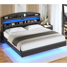 a bed with blue lights on the headboard and foot board is in a room