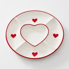 a heart shaped plate with red hearts on the rim and bottom, set against a white background