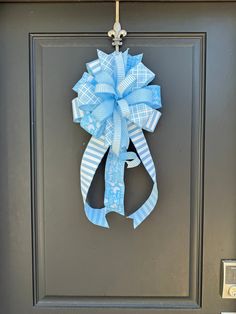 a blue and white bow hanging on a door