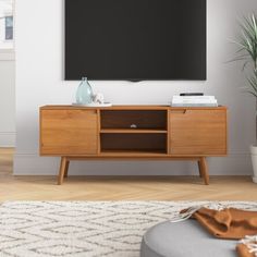 a flat screen tv mounted to the side of a wooden cabinet in a living room