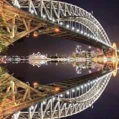 an image of a bridge that is going over the water at night with lights on it