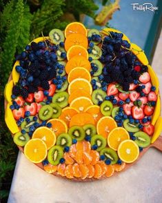 a platter filled with lots of fruit on top of a table