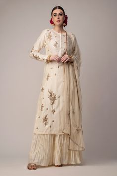 Cream chanderi long kurta with floral embroidery. Paired with cream crinkled skirt and embroidered dupatta.
Components:3
Pattern:Embroidered
Type of Work:Floral
Neckline:Round
Sleeve Type:Long Sleeves
Fabric:Kurta and Skirt: Chanderi, Dupatta: Net
Color:Cream
Other Details:
Embroidered kurta
Floral motifs
Occasion:Wedding - Aza Fashions Handwork Design, Kurta Skirt, Crinkle Skirt, Chanderi Dupatta, Long Kurta, Embroidered Dupatta, Straight Kurta, Women Kurta, Co Ord Set