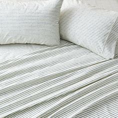 a bed with white and blue striped sheets