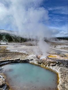 a geyser spewing out steam into the sky