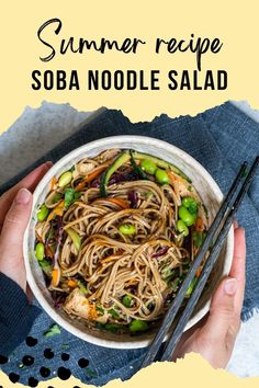 someone holding a bowl of sob noodle salad with chopsticks on the side