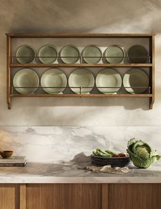 a wooden shelf filled with plates and bowls on top of a counter next to a bowl