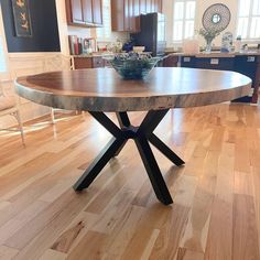 a kitchen with wooden floors and an oval table