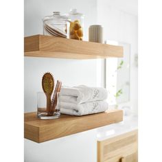 two wooden shelves with towels and toothbrushes on them