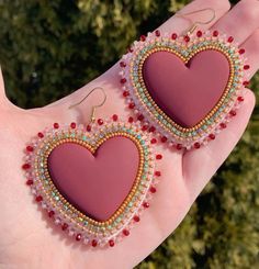 pair of pink heart shaped earrings with beadings and beads on the outside of it