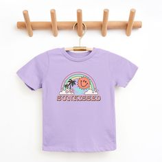 Looking for a cute tee for your kids? We have the perfect Sunkissed Rainbow graphic tee addition to their closet! Also available in toddler tees. Fun Purple T-shirt With Funny Print, Playful Purple Summer T-shirt, Purple Cartoon Print Fun T-shirt, Lavender Trendy T-shirt For Summer, Trendy Lavender T-shirt For Summer, Trendy Lavender Summer T-shirt, Trendy Lavender Short Sleeve T-shirt, Purple Funny Print T-shirt For Summer, Fun Purple Crew Neck T-shirt