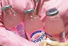 a woman in pink shirt holding three bottles of water