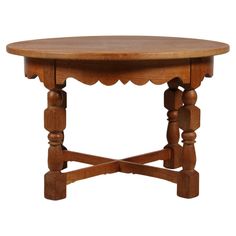 a wooden table with scalloped legs and a round top on an isolated white background