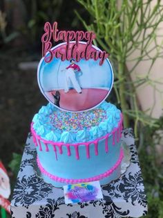 a blue birthday cake with sprinkles and a happy birthday card on top