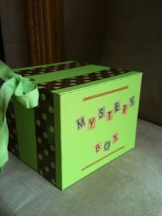 a green box with a bow on the top that says mystery box next to it