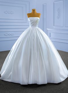 a white wedding dress on display in front of a mannequin's head