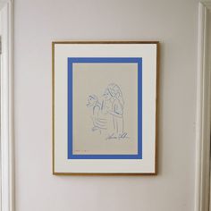 a blue and white drawing hanging on the wall