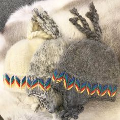 two hats laying next to each other on top of a fur covered animal's skin