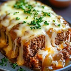 a meatloaf casserole on a plate with cheese and green garnish