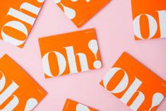 orange and white stickers with the word oh on them are scattered across a pink surface