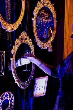 a woman is looking at her reflection in the mirror while she holds it up with both hands