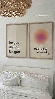 two pictures hanging on the wall above a bed in a room with white sheets and pillows