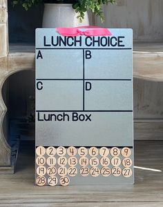 a lunch box sign sitting next to a potted plant