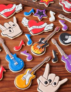 many decorated cookies with guitars and music instruments on top of a wooden table next to each other