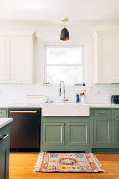 a kitchen with green cabinets and an area rug