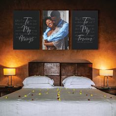 a bed with two pictures hanging on the wall above it and flowers in front of it