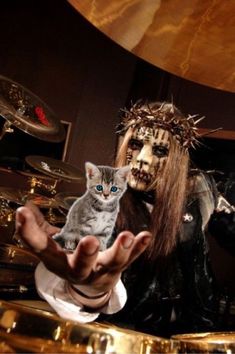 a man holding a cat in front of him and another person with makeup on his face