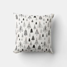 a black and white pillow with trees on it