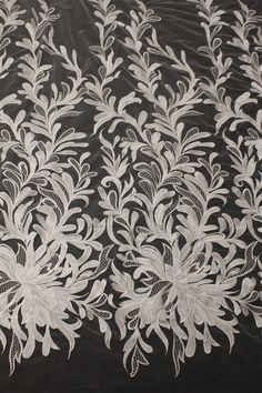 white lace on black fabric with flowers and leaves