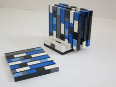 two pieces of art made out of legos sitting on a table next to each other