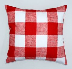 a red and white checkered pillow sitting on top of a table