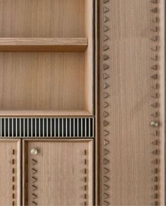 a close up of a wooden shelf with drawers and shelves on each side that have decorative designs