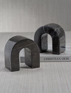 two black marble bookends sitting next to each other on top of a table